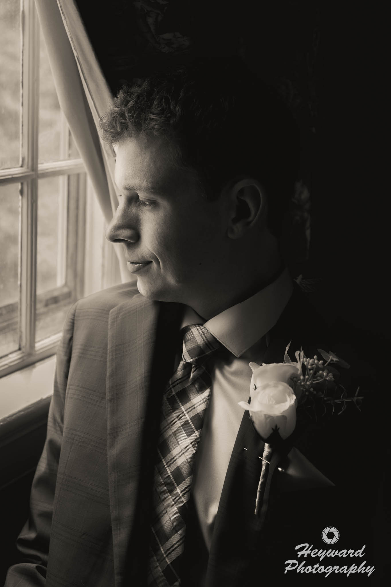 Groom looking out window.