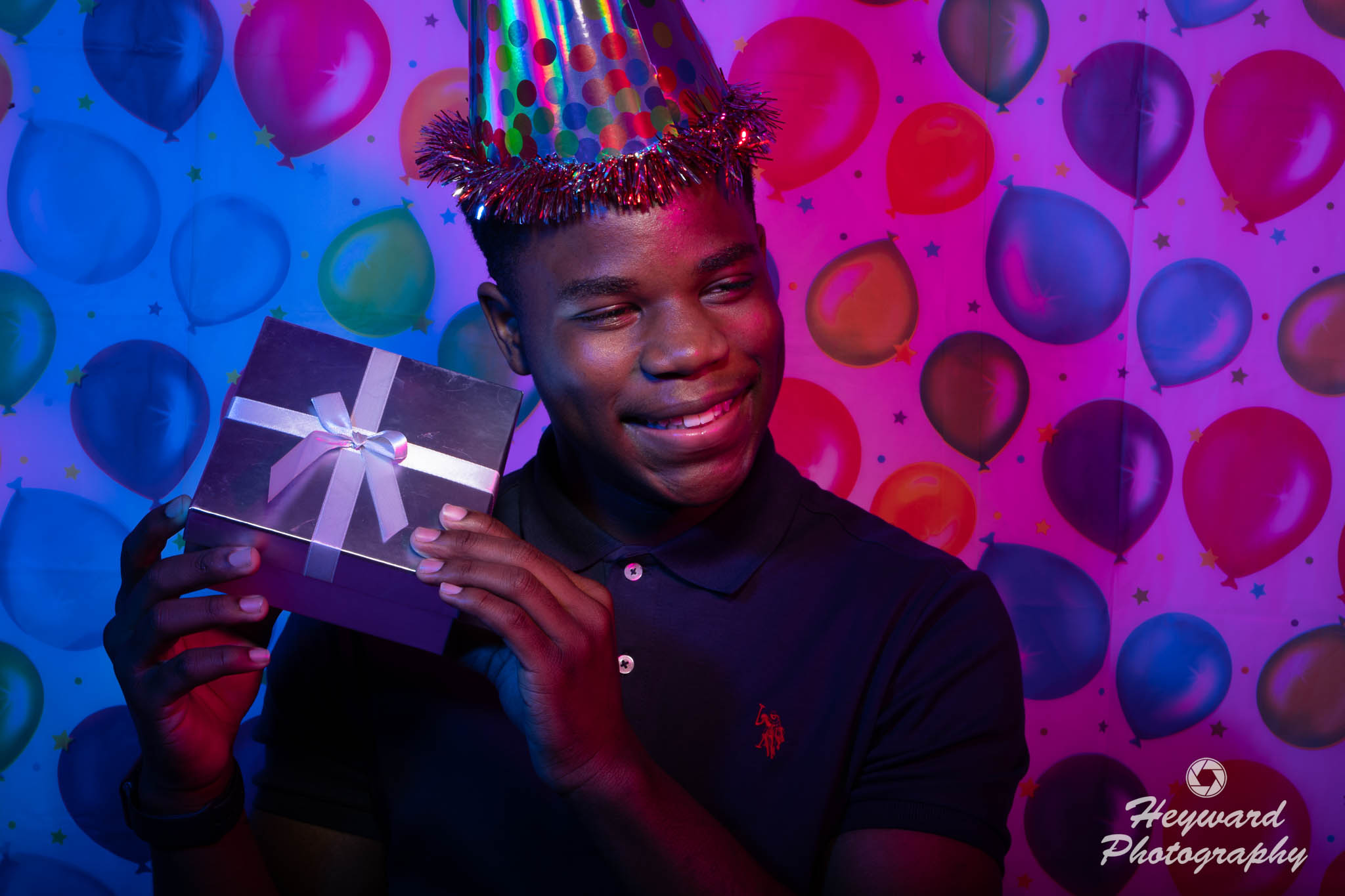 Black male holding a birthday gift.