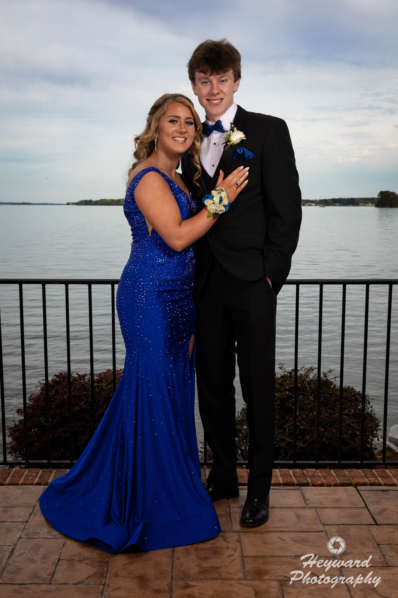 A young couple pose for a full length photo.